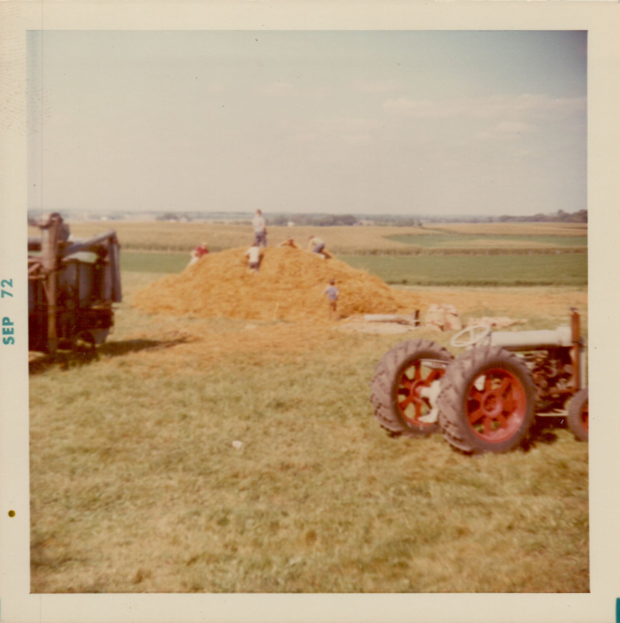 A picture from the 1972 Rogers threshing show. Children play in the straw pile created by the rescued thresher.